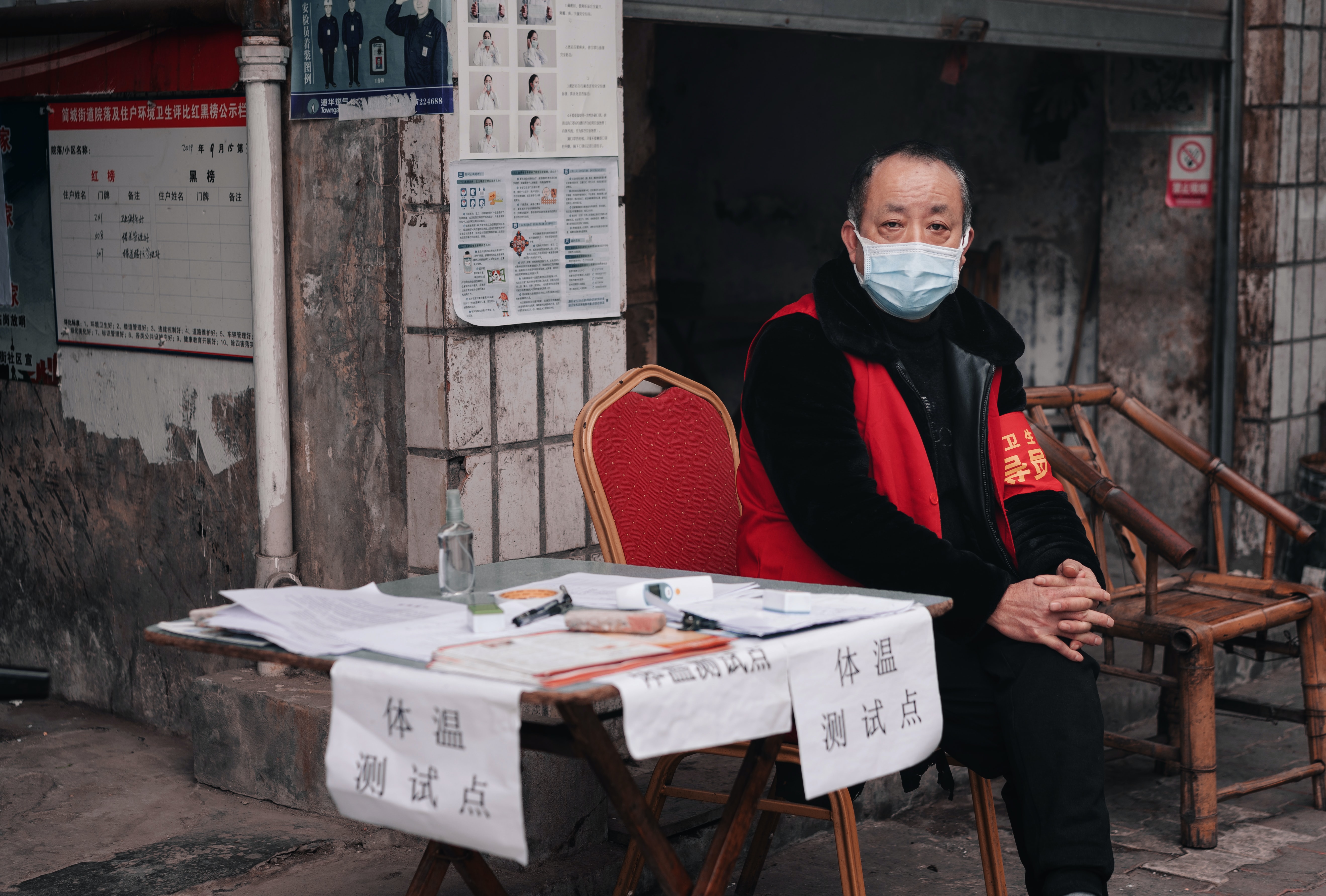 Man checks body temperature in a housing estate in China