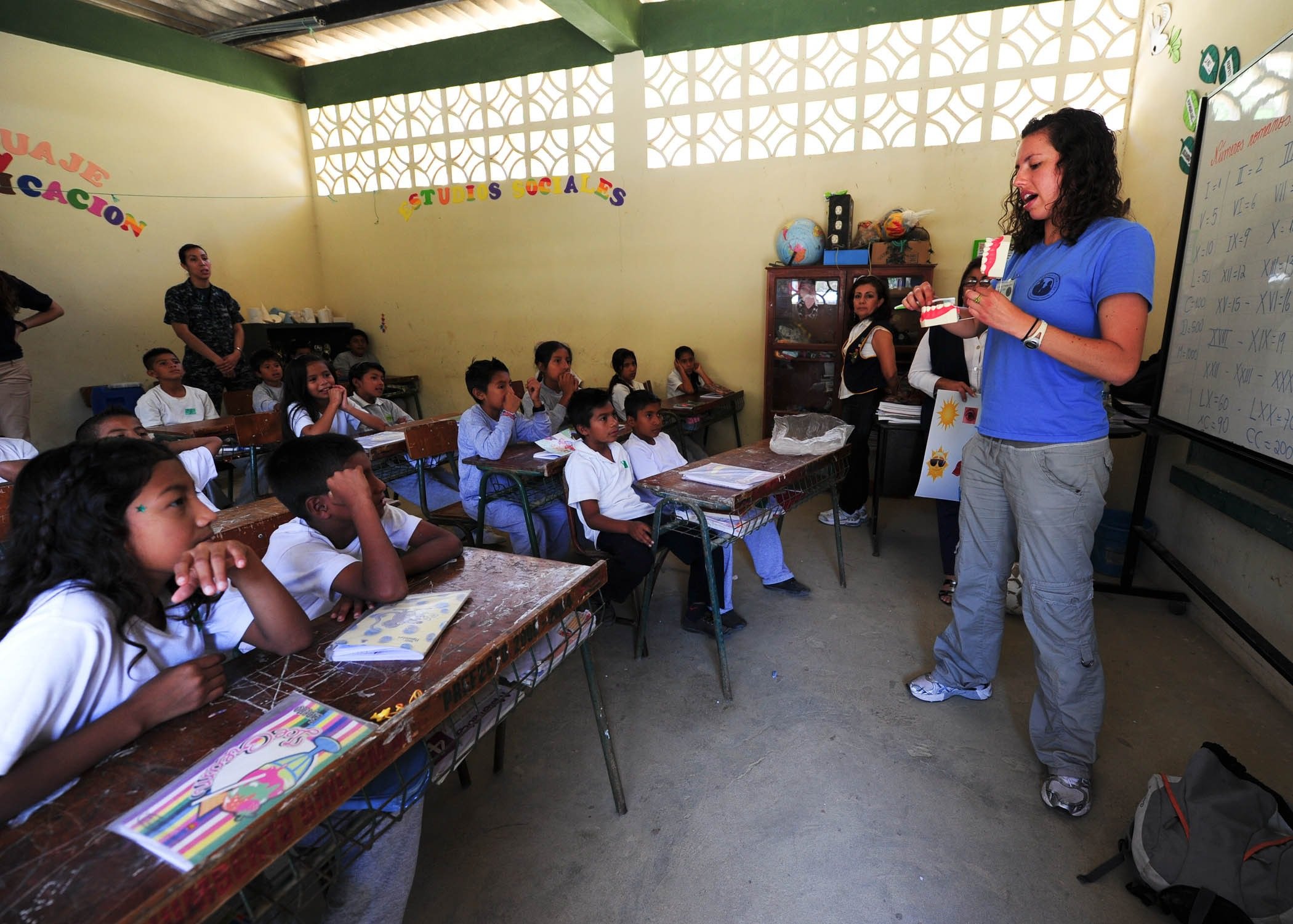 A teacher stands at the front of a classroom in Latin America