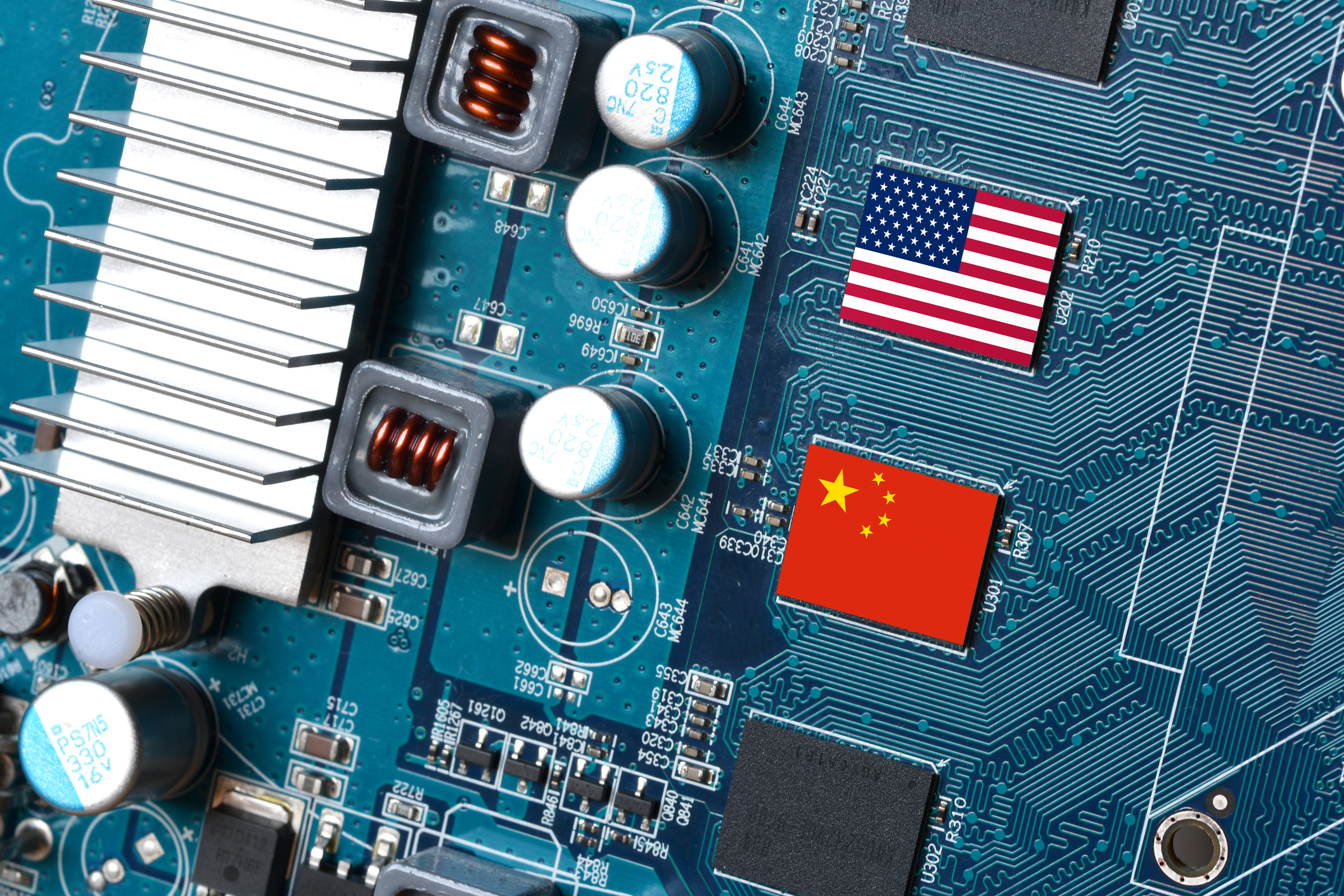 Close-up of a computer motherboard featuring the national flags of the United States and China printed on two chips, symbolising technological competition between the two countries.