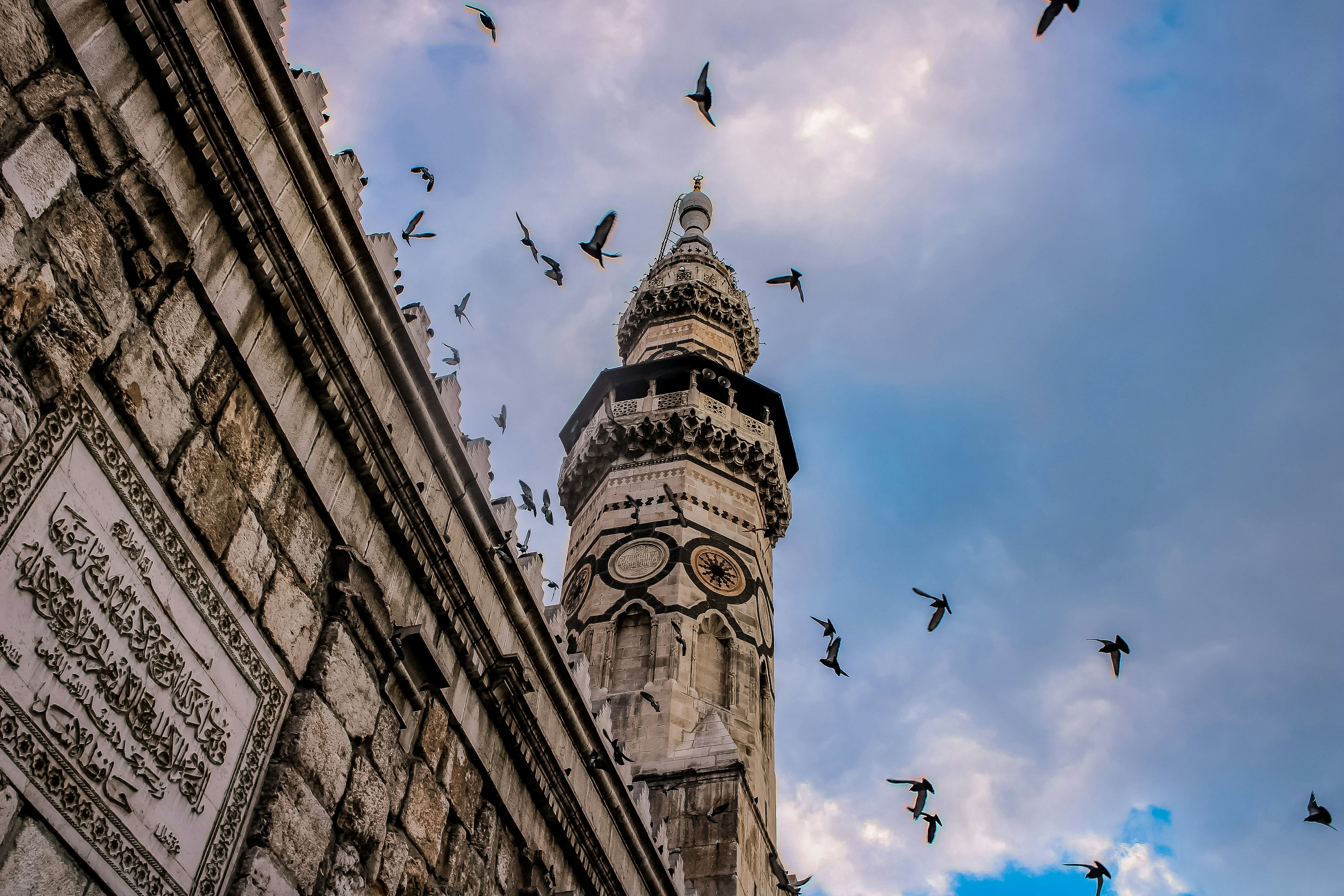 Pigeons fly around a mosque in Damascus