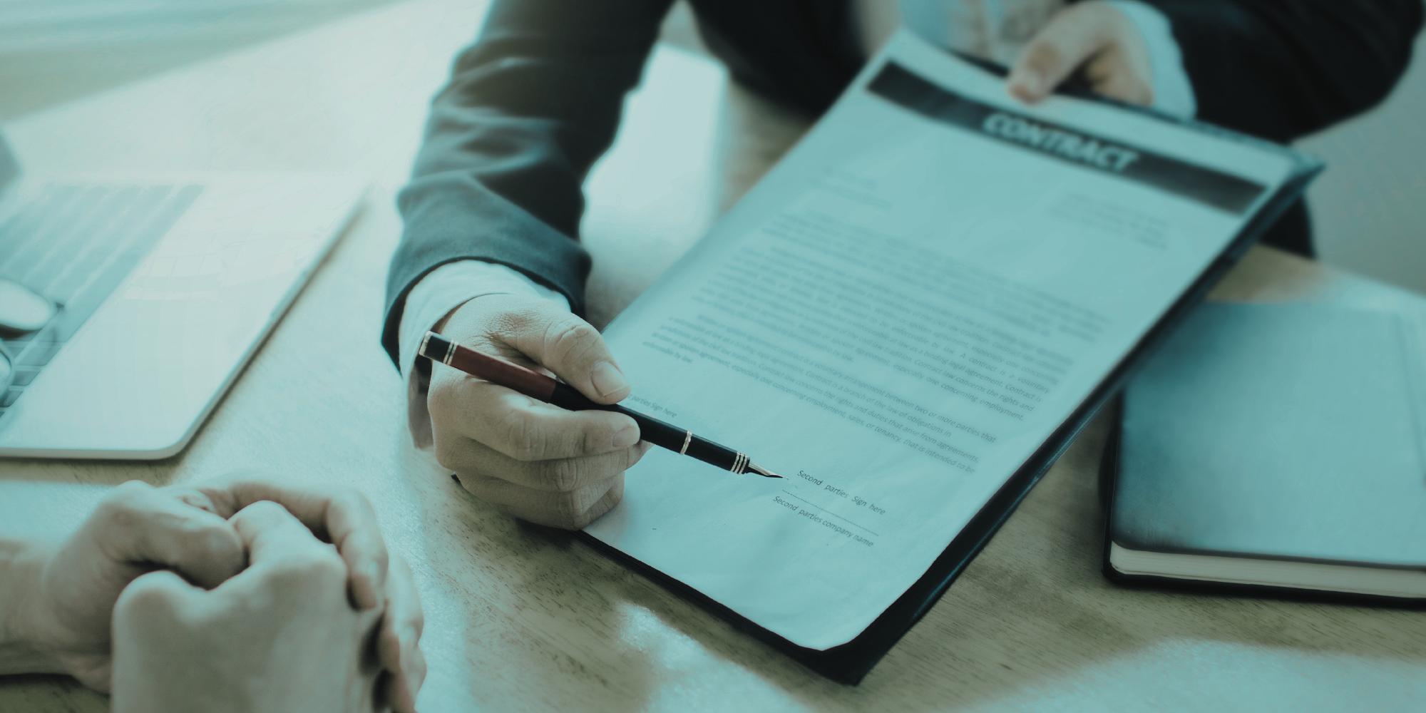 Close-up photo of someone presenting a contract to be signed