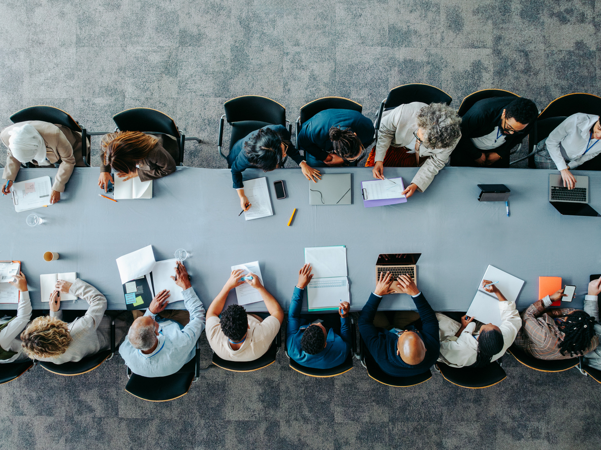 Collaborative work image, row of people sat at desk from above