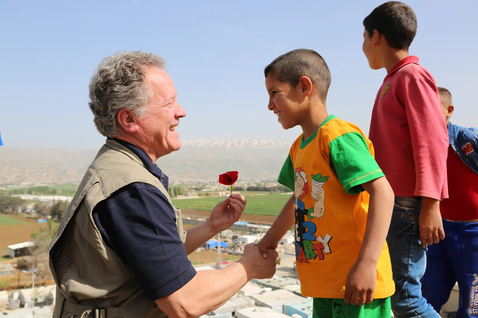 Governor Beasley shakes the hand of a child in Somalia, both smiling 