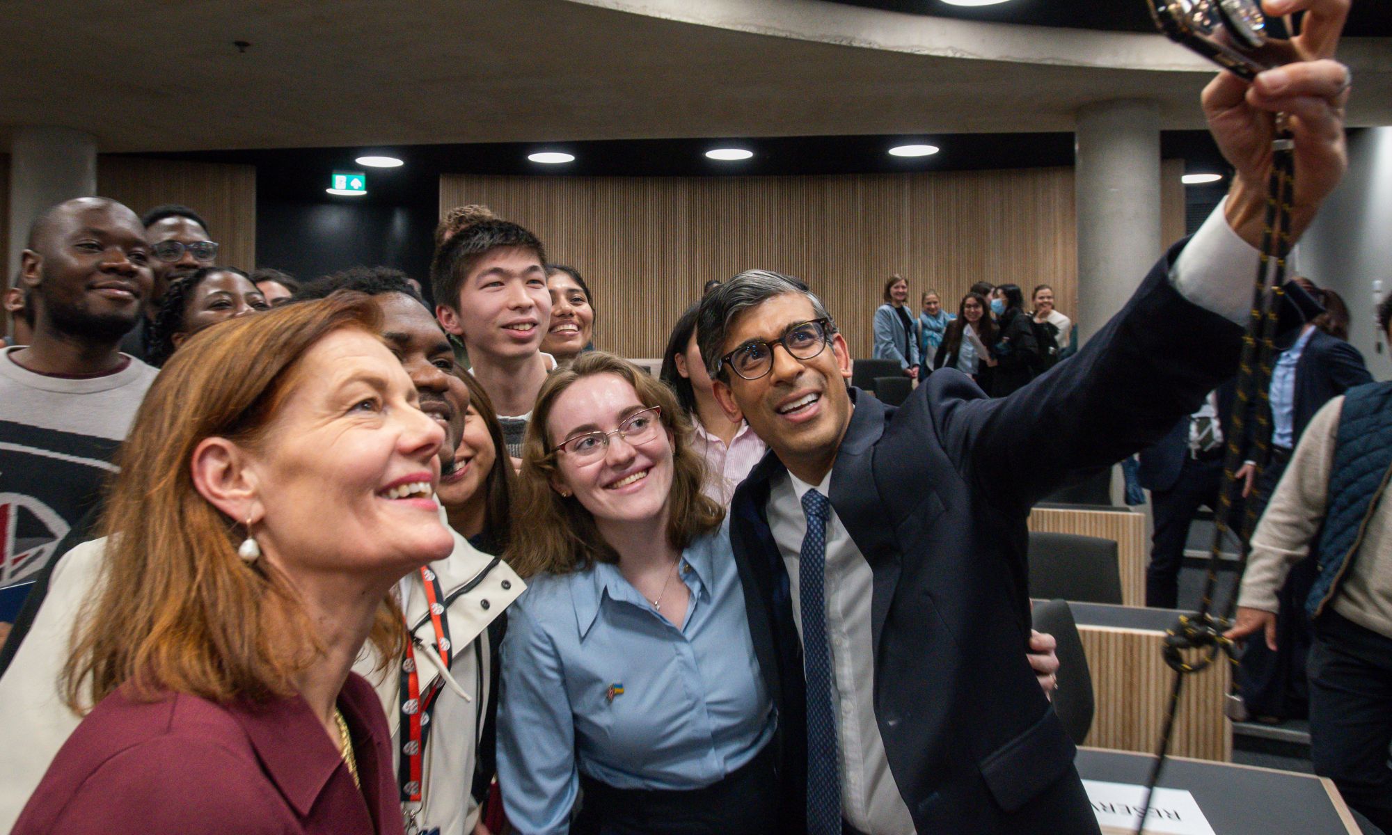 Rishi Sunak takes a selfie with students and Dean Ngaire Woods in a lecture theatre.