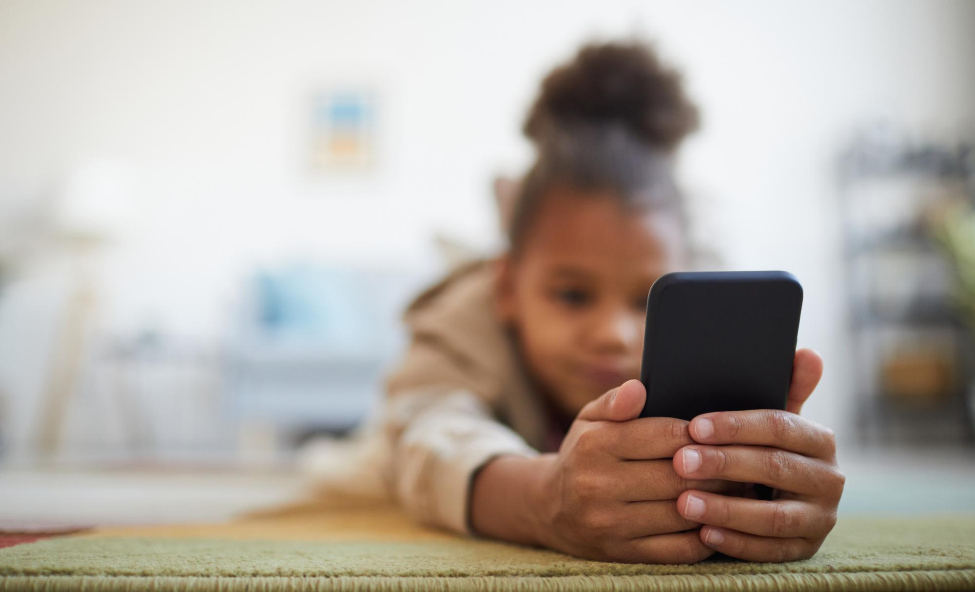 Child using smartphone, childs face is blurred