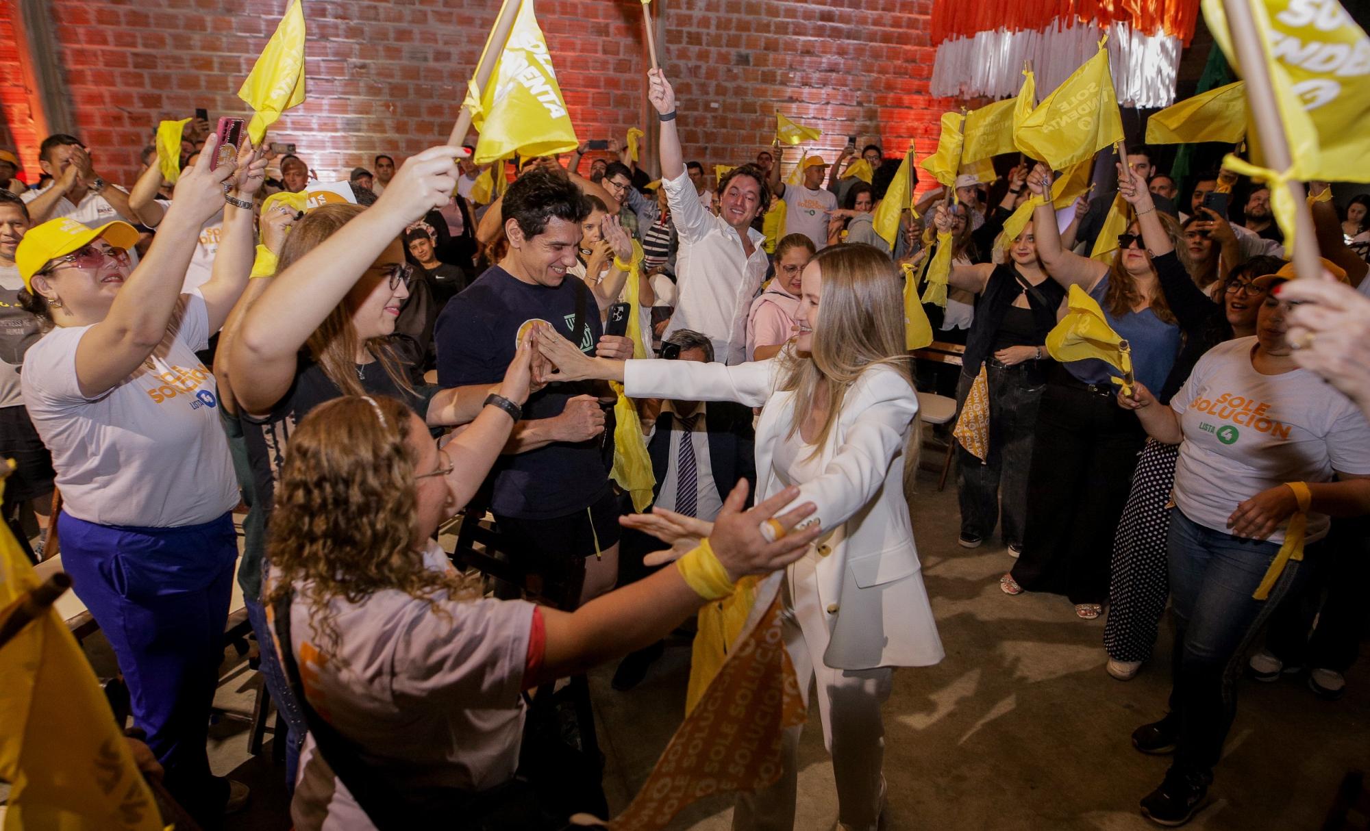Soledad greets people surrounded by flags