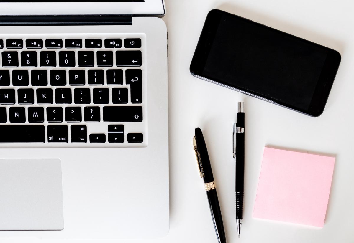 Laptop, pens, notepad and phone
