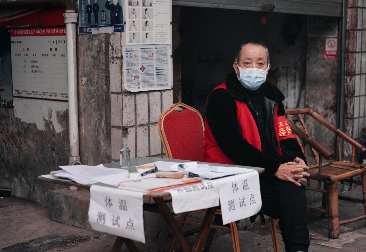 Man checks body temperature in a housing estate in China