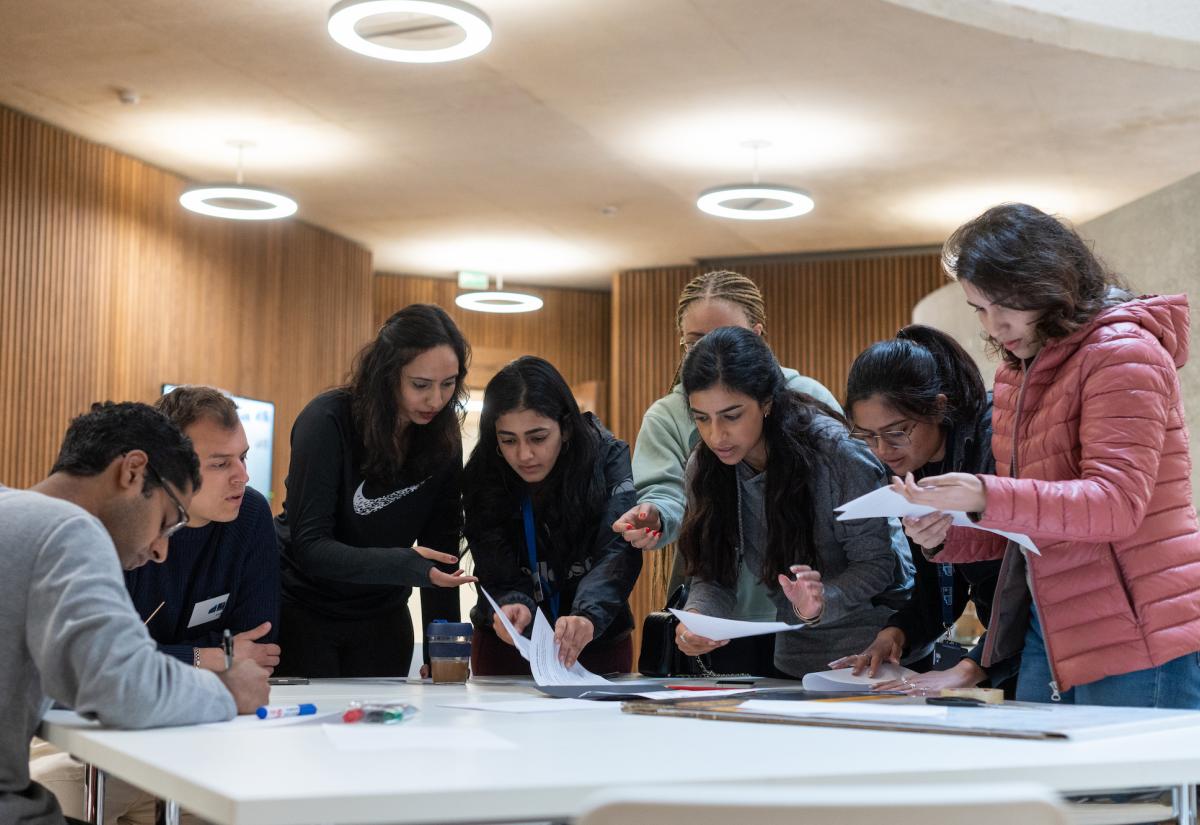 Eight MPP students take part in group activity round a table.