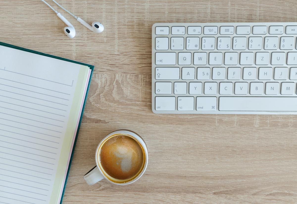 Notepad, keyboard and a cup of coffee