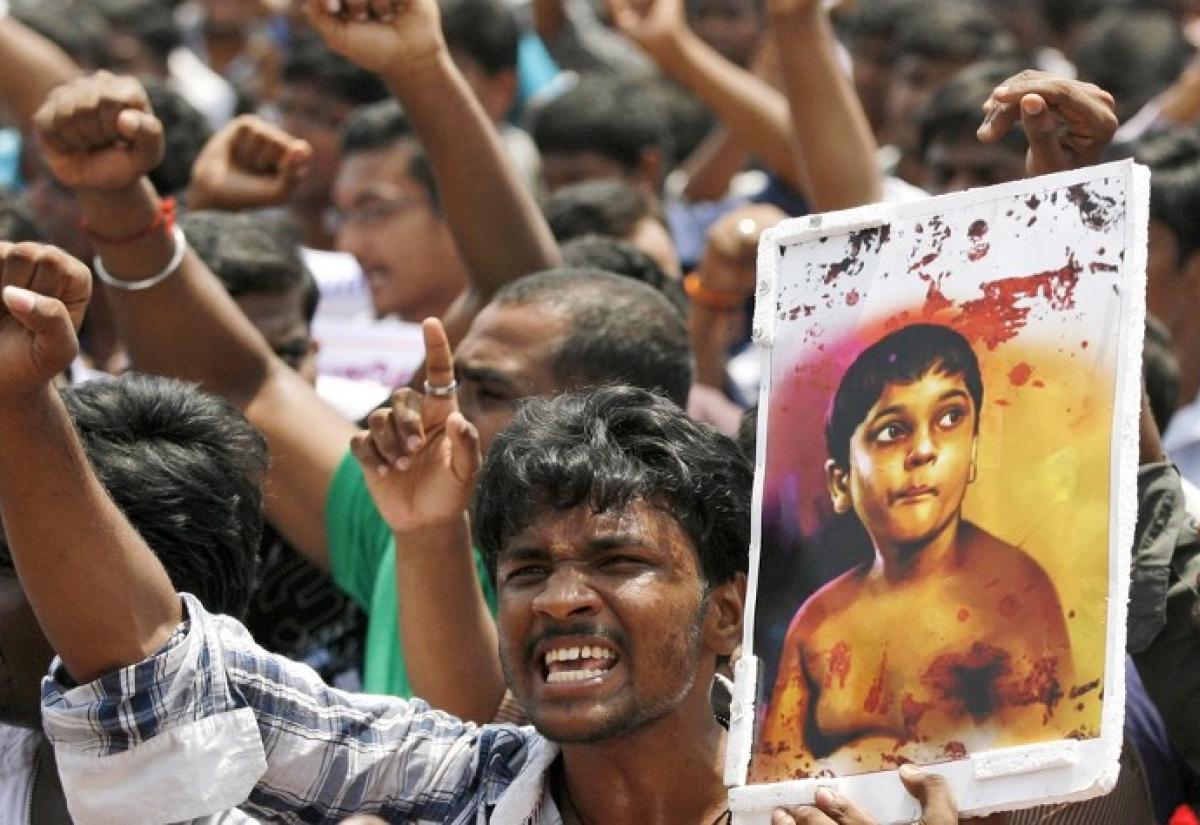ChatGPT said: A group of protesters with raised fists; one holds a placard showing a young boy with bloodstains, symbolizing outrage over violence or injustice.