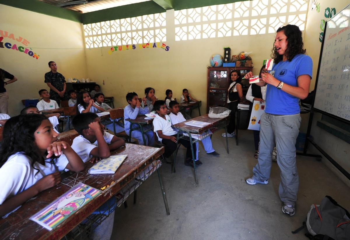 A teacher stands at the front of a classroom in Latin America 