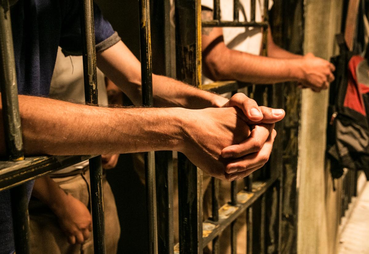 Hands lent out of prison rails