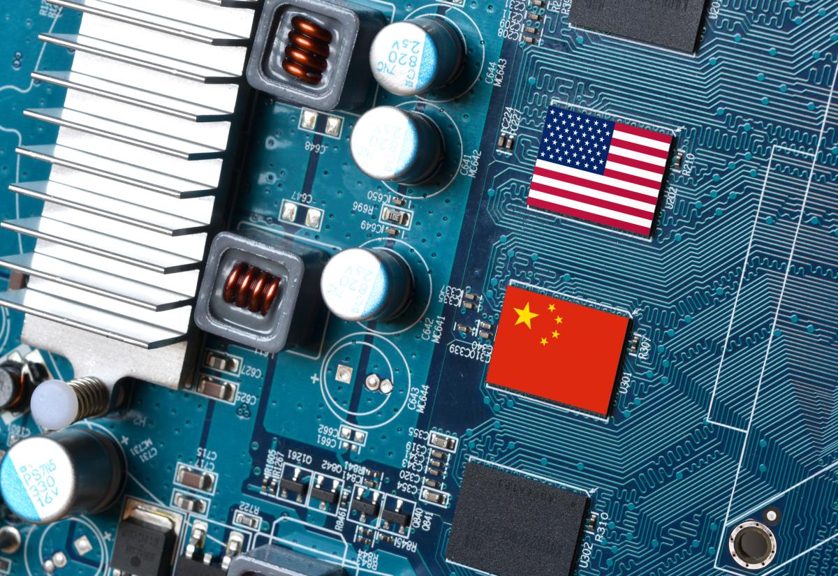 Close-up of a computer motherboard featuring the national flags of the United States and China printed on two chips, symbolising technological competition between the two countries.