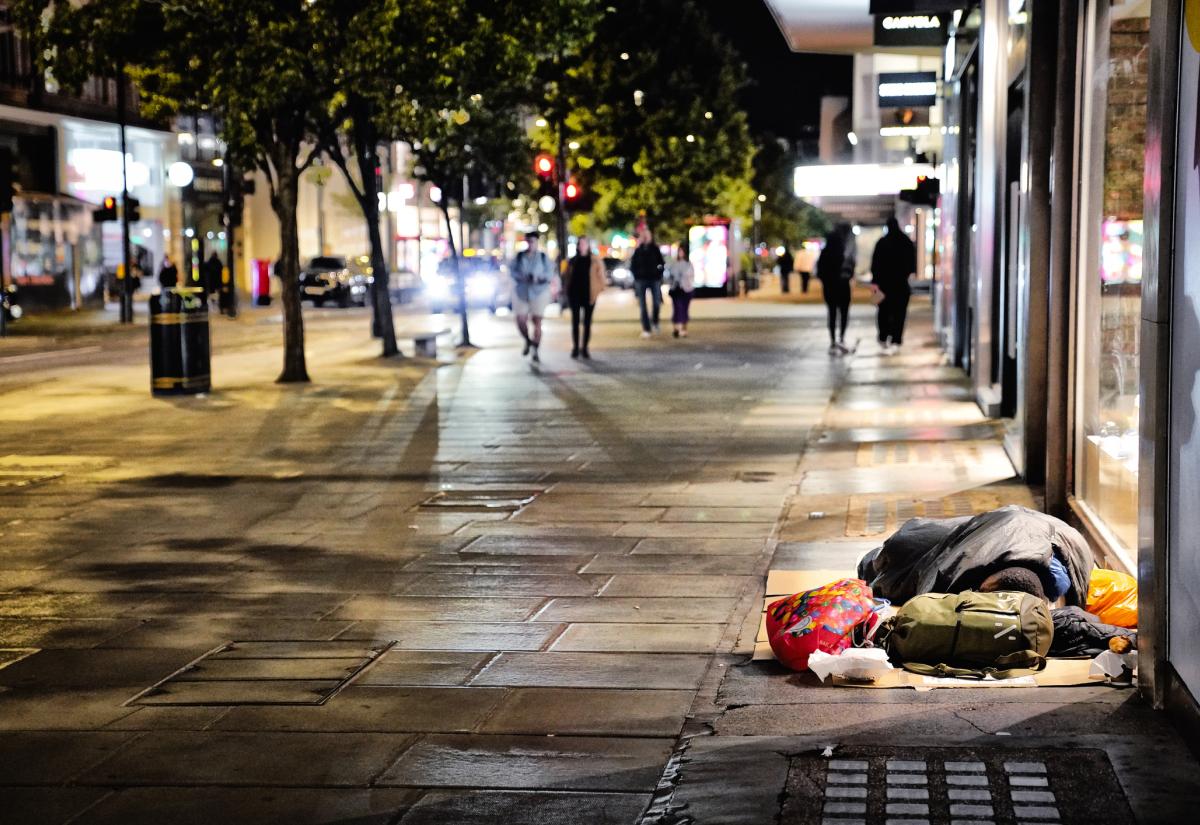 A homeless person sleeps on the street in London