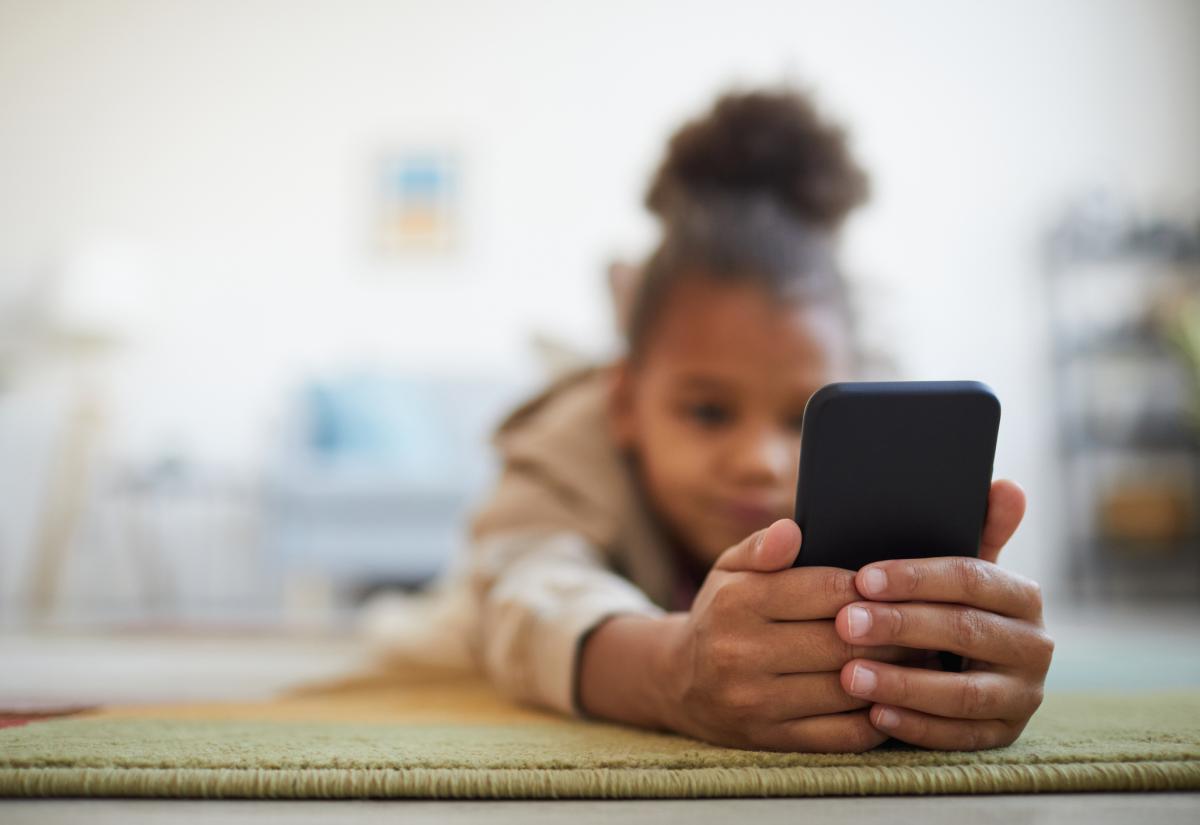 Child using smartphone, childs face is blurred