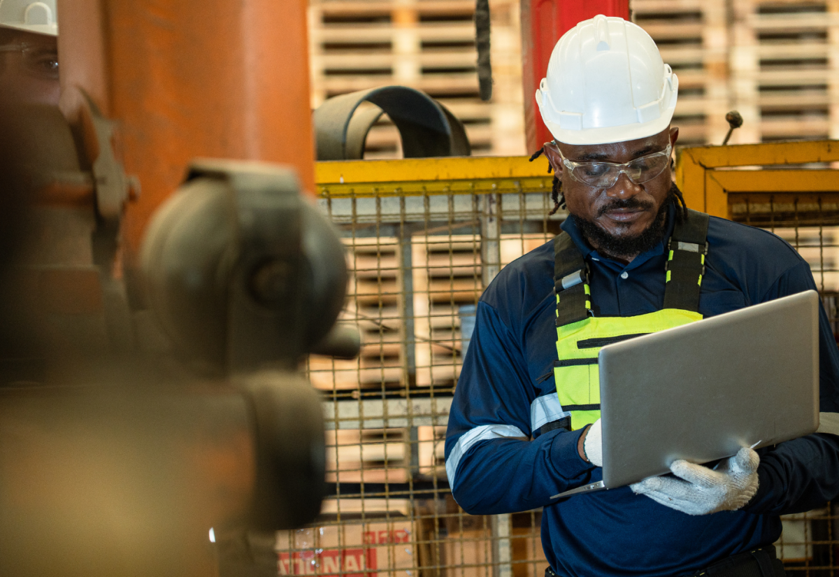 Man wearing hard hat looking on a laptop