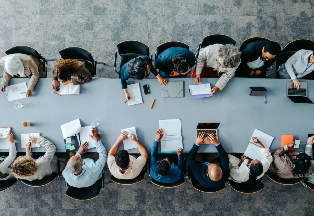 Collaborative work image, row of people sat at desk from above