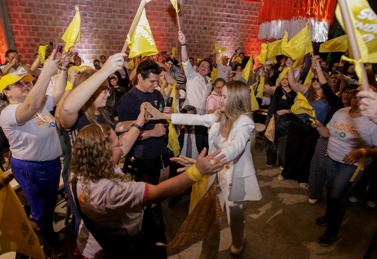 Soledad greets people surrounded by flags