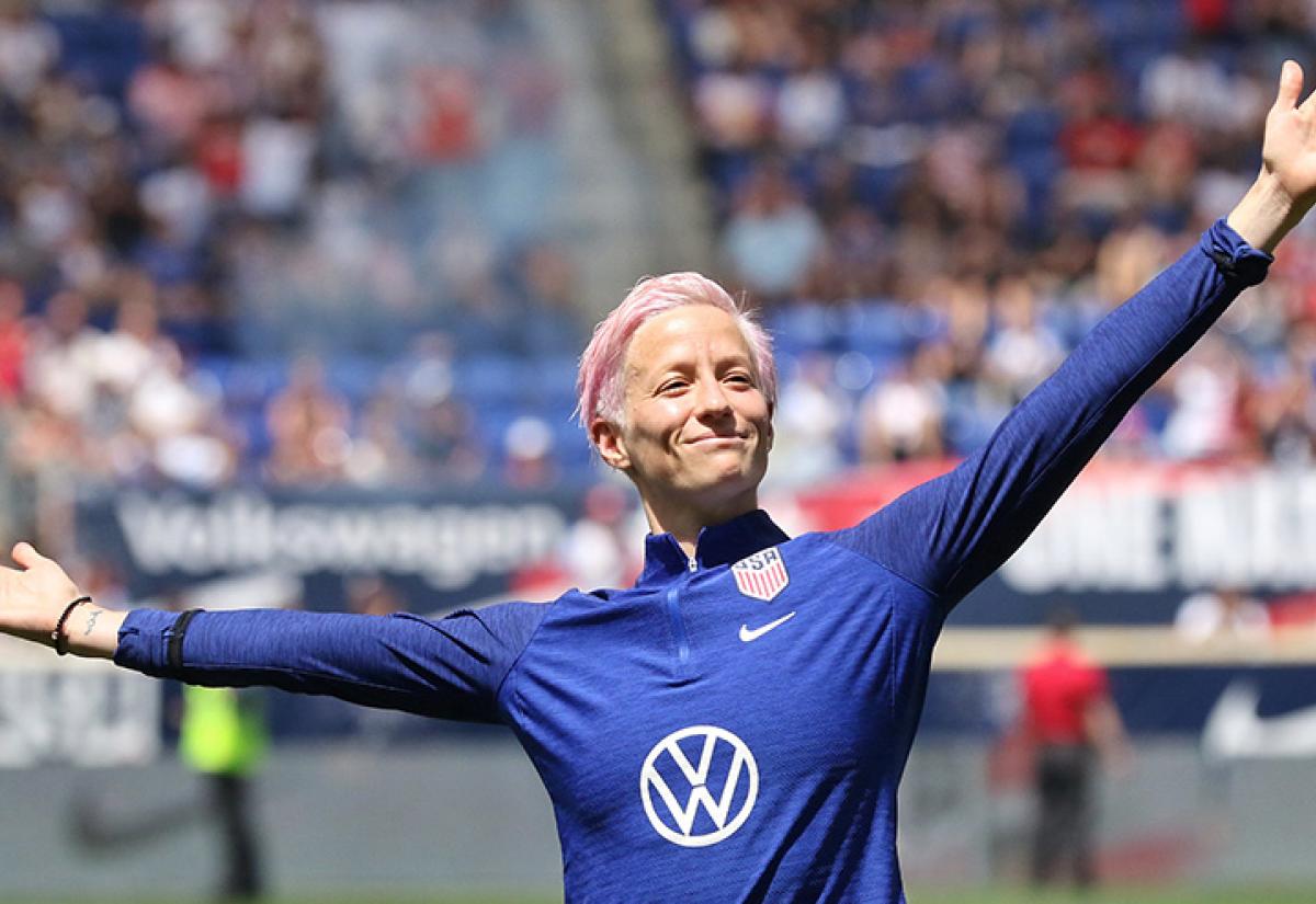 Megan Rapinoe with her arms outstretched